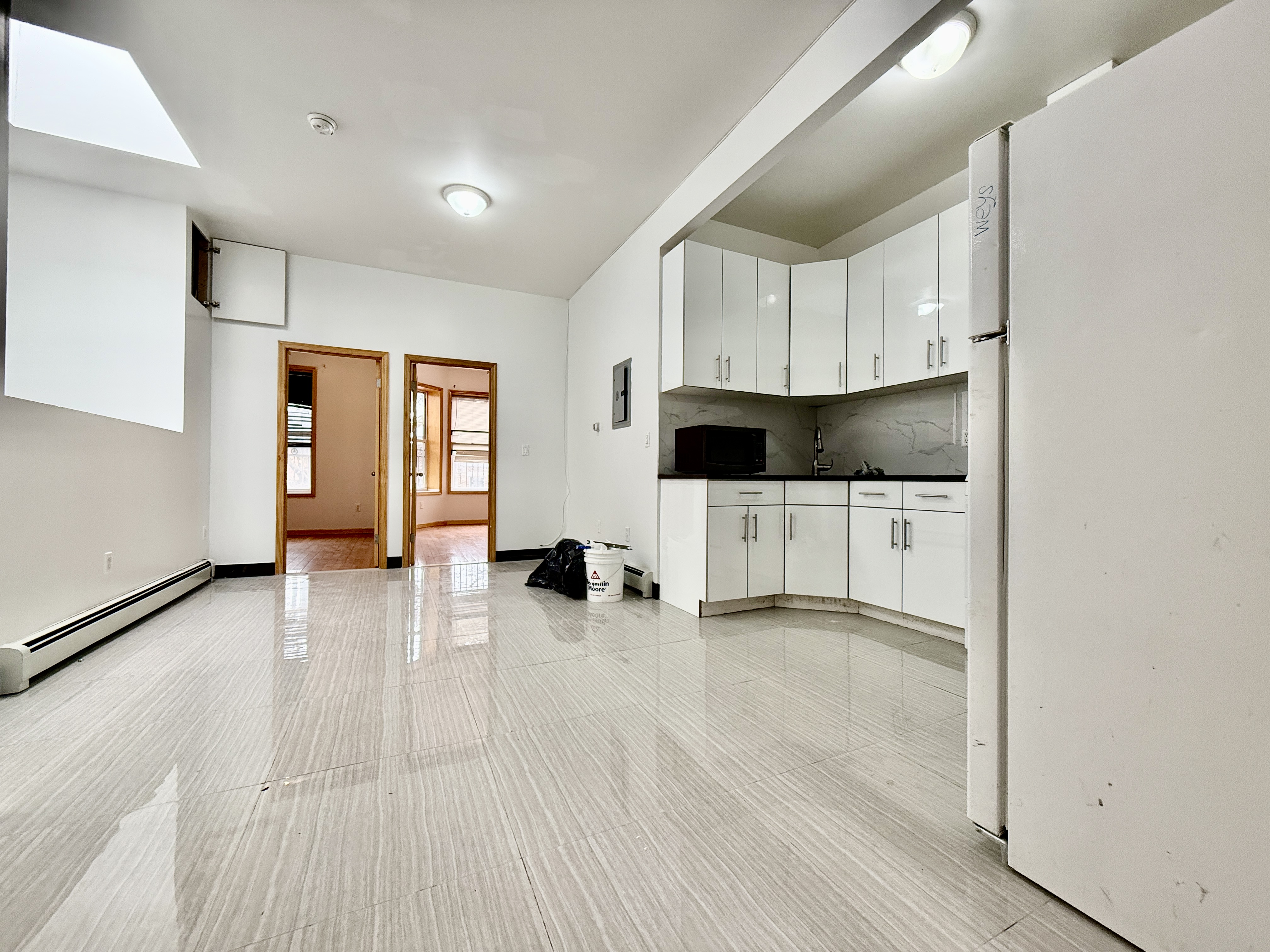 543 53rd Street, Unit 1 Brooklyn, NY 11220 - Photo 6 of 8 a view of a kitchen with wooden floor and electronic appliances