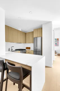 a kitchen with a table chairs refrigerator and cabinets