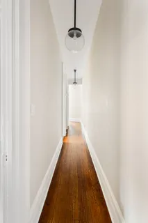 a view of a hallway with wooden floor