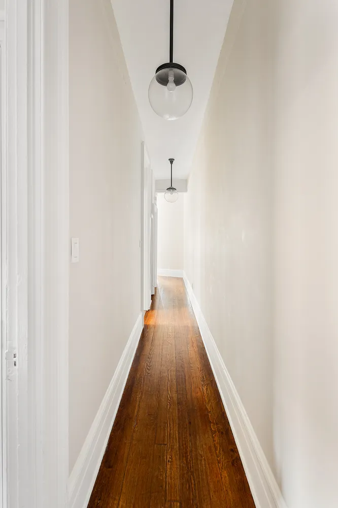 a view of a hallway with wooden floor