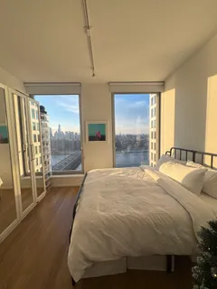 a bed sitting in a spacious bedroom next to a window