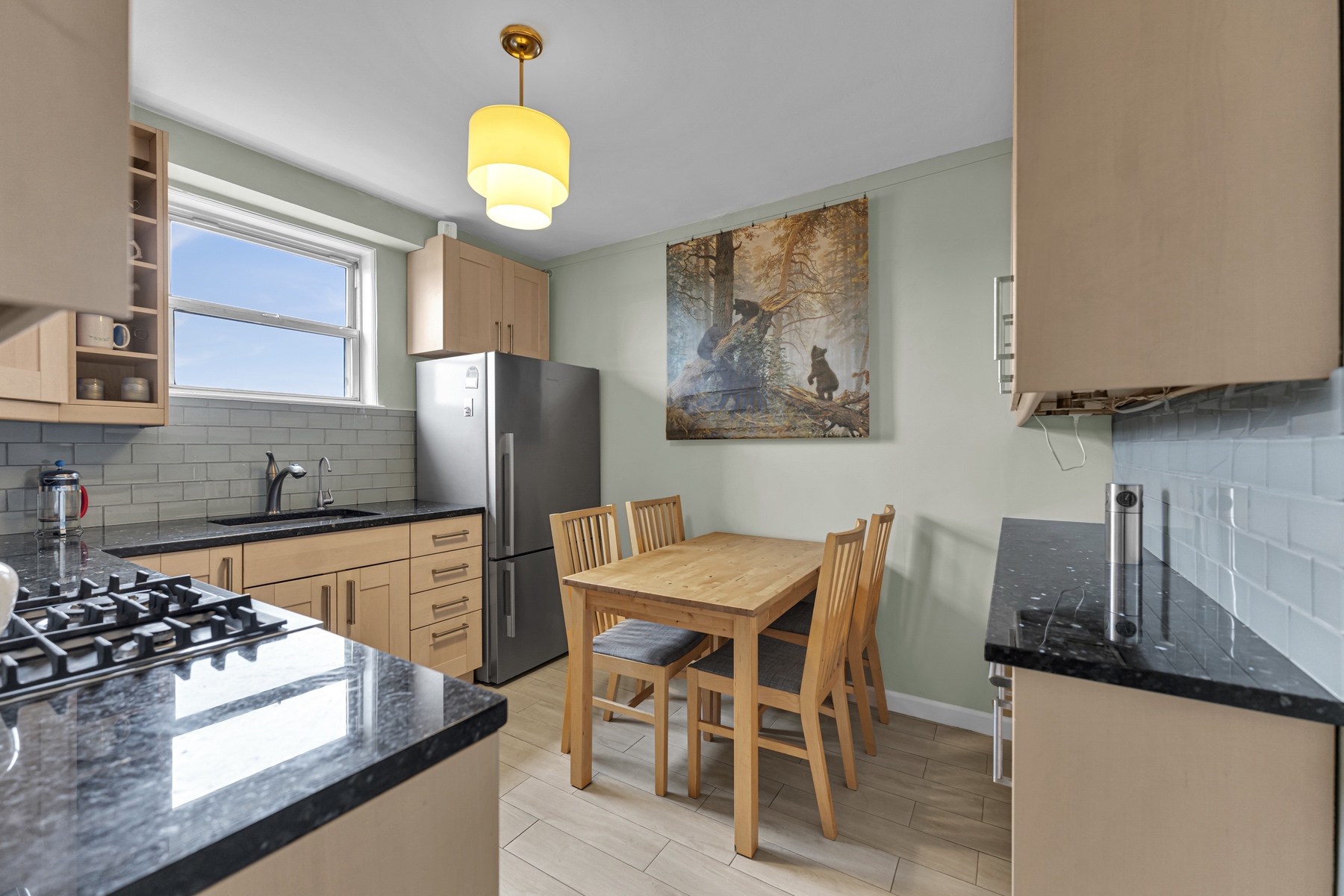 5800 Arlington Avenue, Unit 6V Bronx, NY 10471 - Photo 10 of 15 a kitchen with stainless steel appliances granite countertop a stove a refrigerator a sink a dining table and chairs