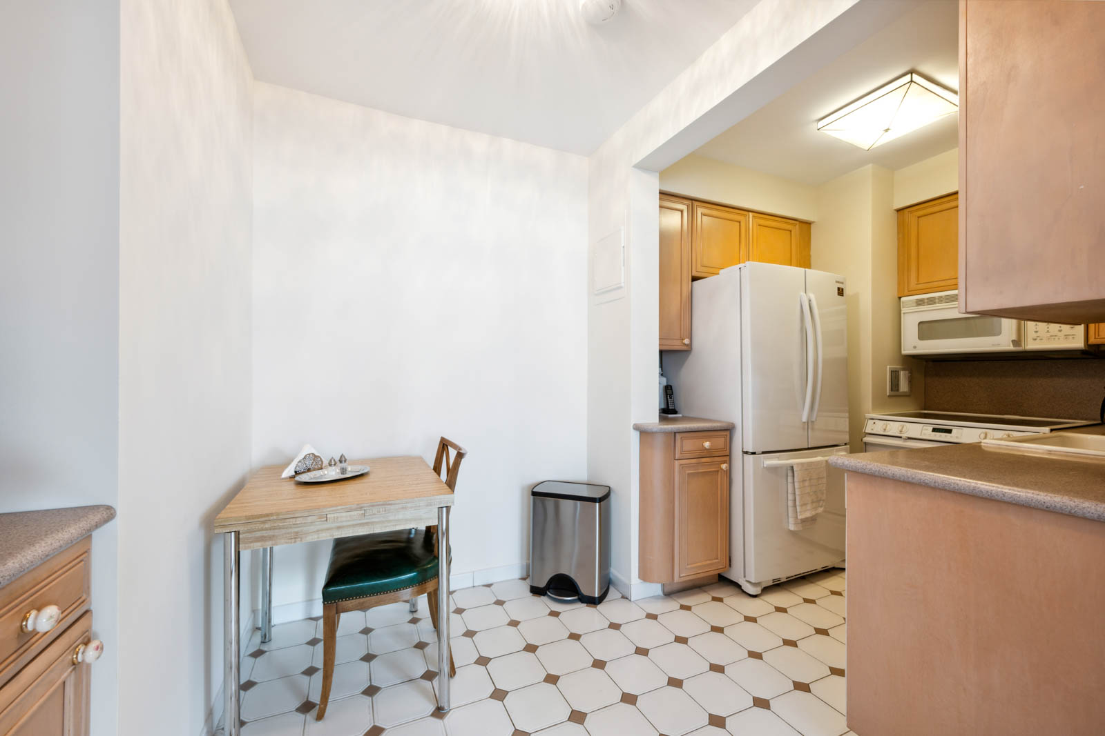 300 East 54th Street, Unit 34GF Manhattan, NY 10022 - Photo 9 of 16 a kitchen with refrigerator and cabinets