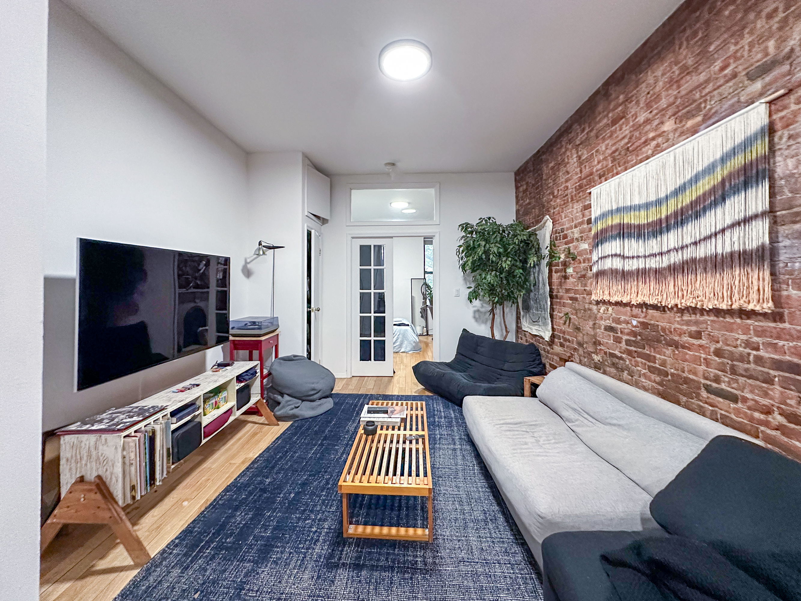 213 East 5th Street, Unit 5 Manhattan, NY 10003 - Photo 2 of 17 a living room with furniture and a flat screen tv