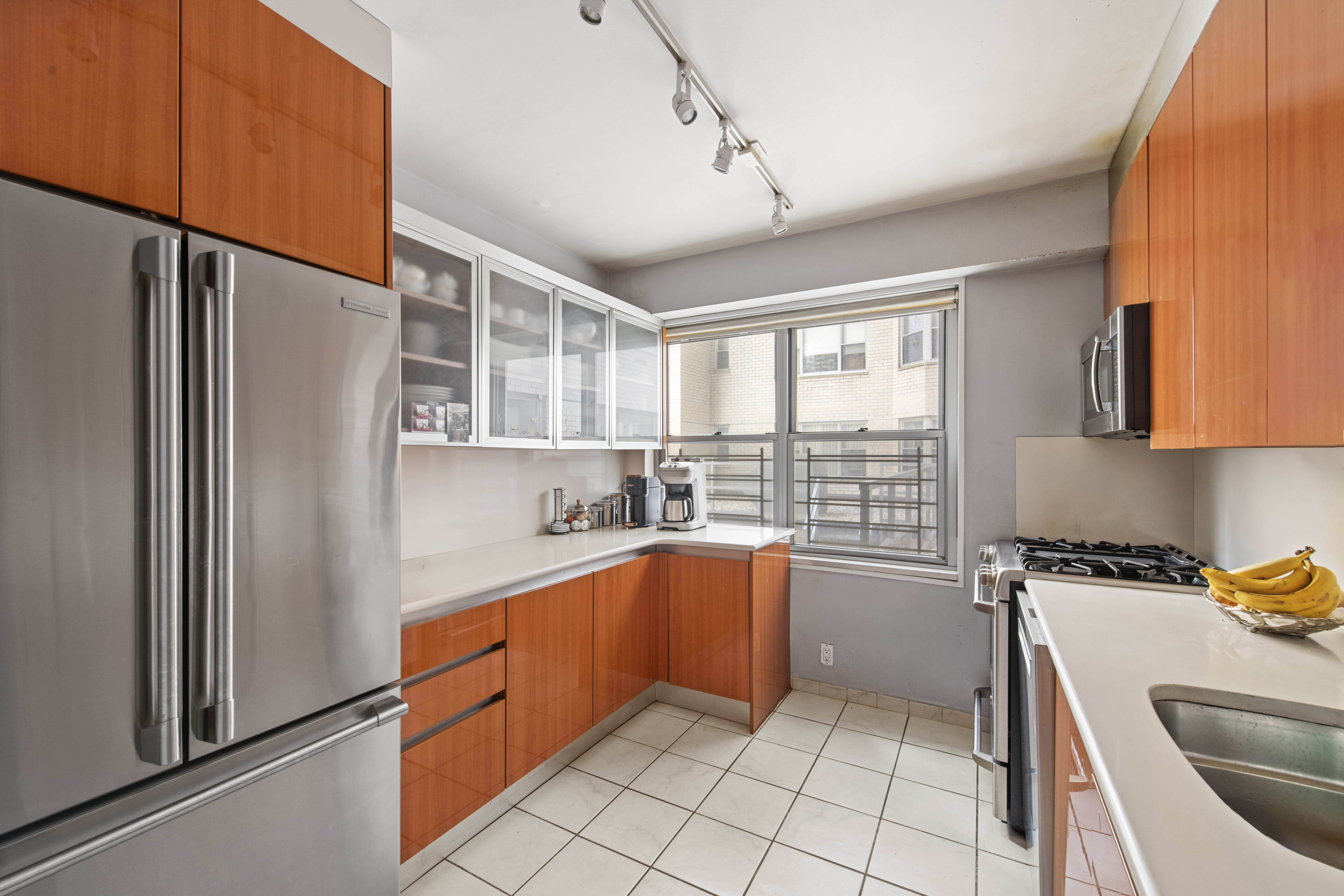 400 East 56th Street, Unit 3D Manhattan, NY 10022 - Photo 9 of 24 a kitchen with stainless steel appliances granite countertop a refrigerator and a sink