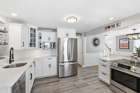 a kitchen with a refrigerator sink and wooden floor