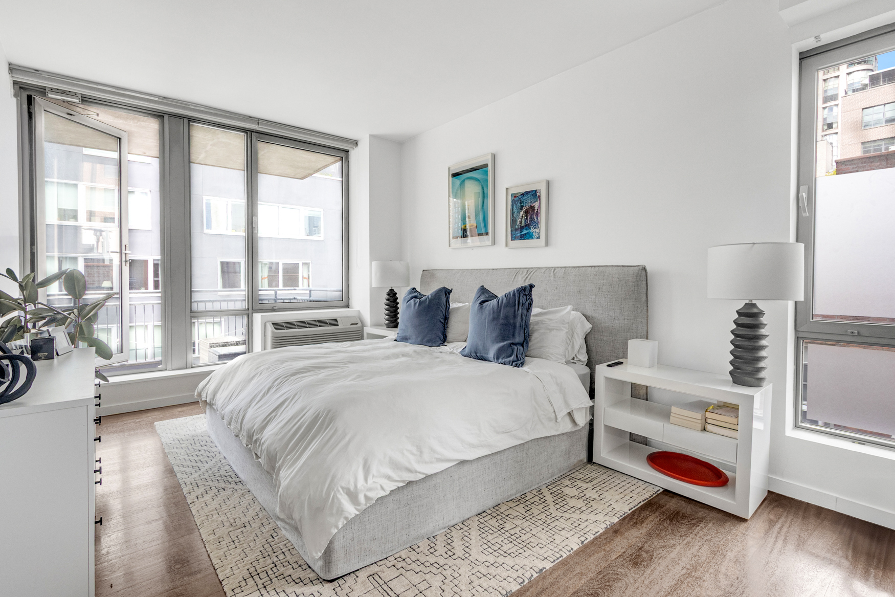 444 West 19th Street, Unit 701 Manhattan, NY 10011 - Photo 5 of 11 a bedroom with a bed and a large window with the outer view