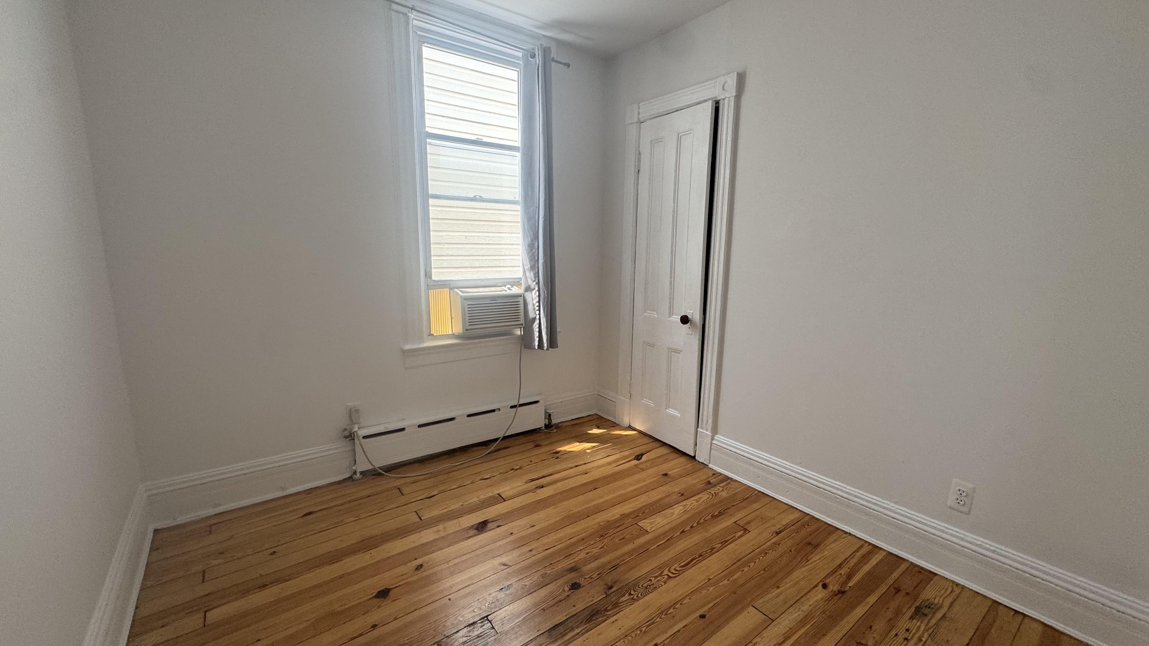 196 Seeley Street, Unit 2 Brooklyn, NY 11218 - Photo 6 of 7 an empty room with wooden floor and windows