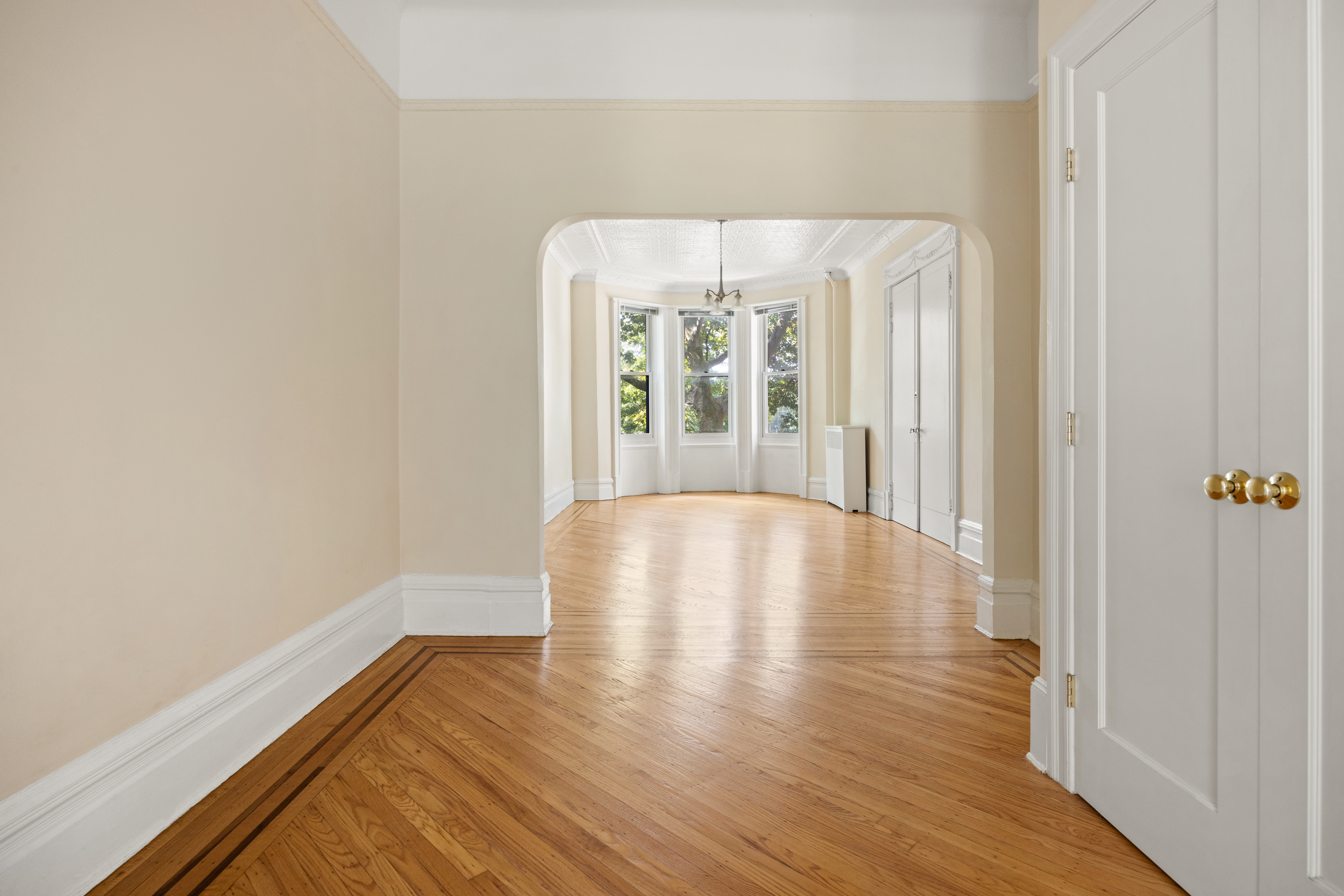 273 Windsor Place Brooklyn, NY 11218 - Photo 5 of 29 a view of an empty room with wooden floor and a window