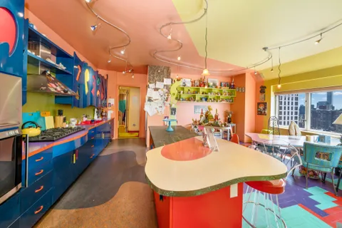 a kitchen with stainless steel appliances kitchen island granite countertop a table chairs and a view of living room