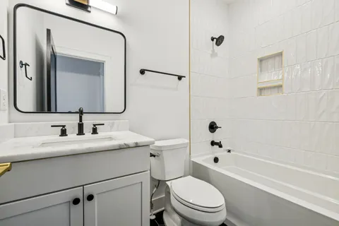 a bathroom with a toilet a sink a bathtub and a mirror