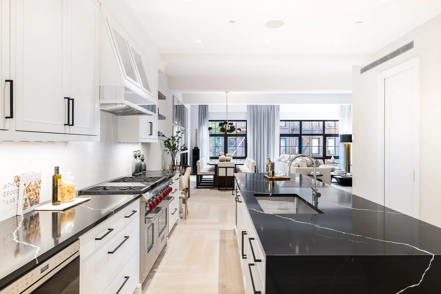 a kitchen with stainless steel appliances granite countertop a sink dishwasher stove and white cabinets next to a window