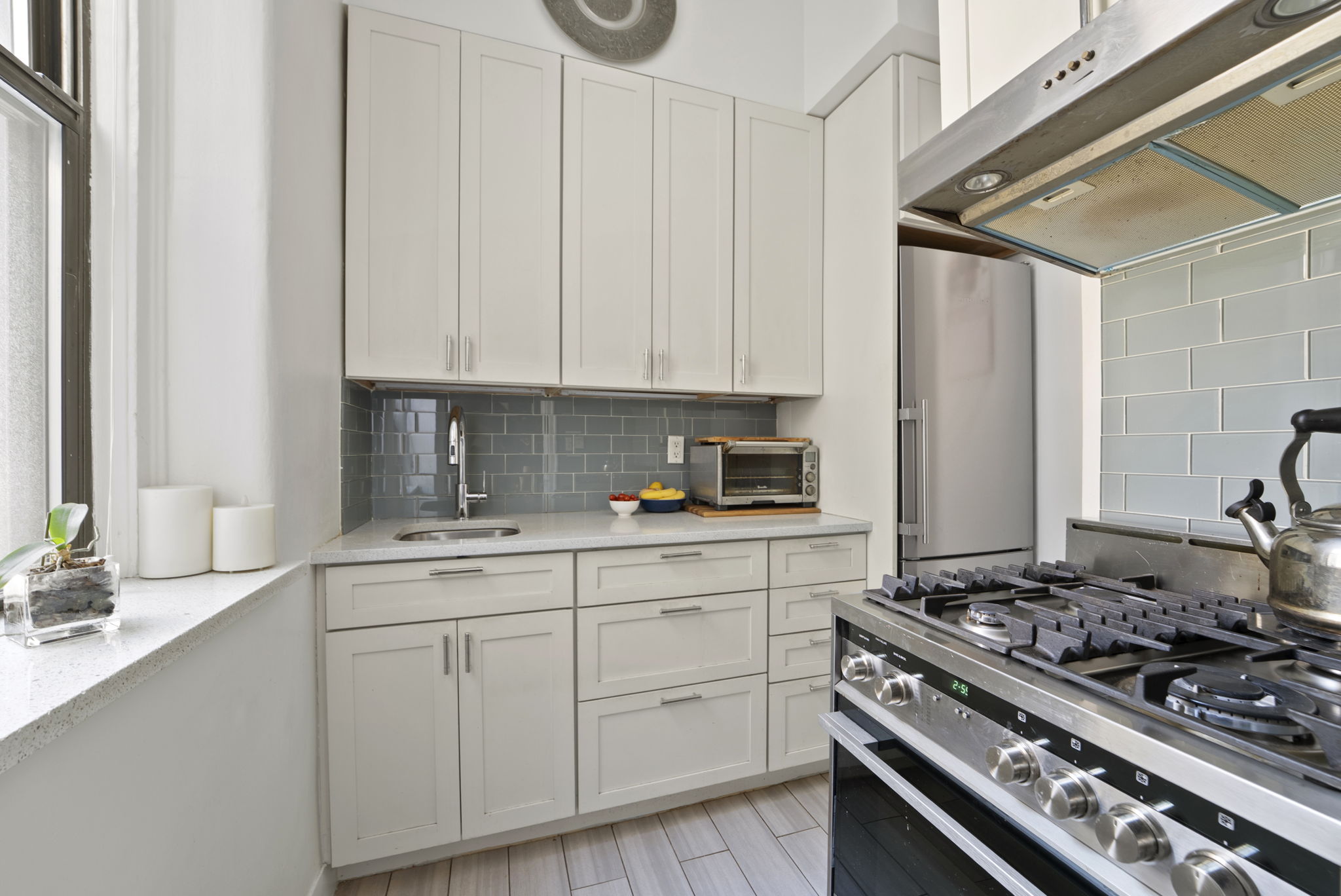 205 West 54th Street, Unit 5F Manhattan, NY 10019 - Photo 3 of 6 a kitchen with white cabinets and appliances