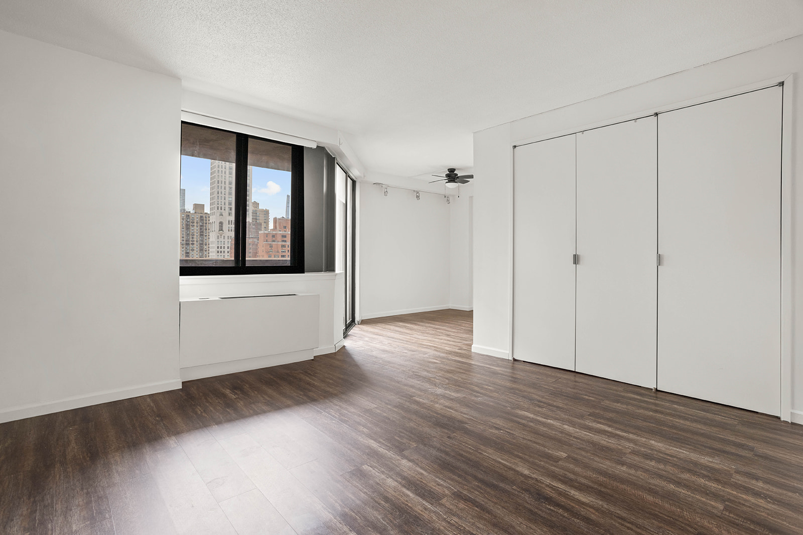 233 East 86th Street, Unit 16A Manhattan, NY 10028 - Photo 1 of 7 a view of an empty room with wooden floor and a window