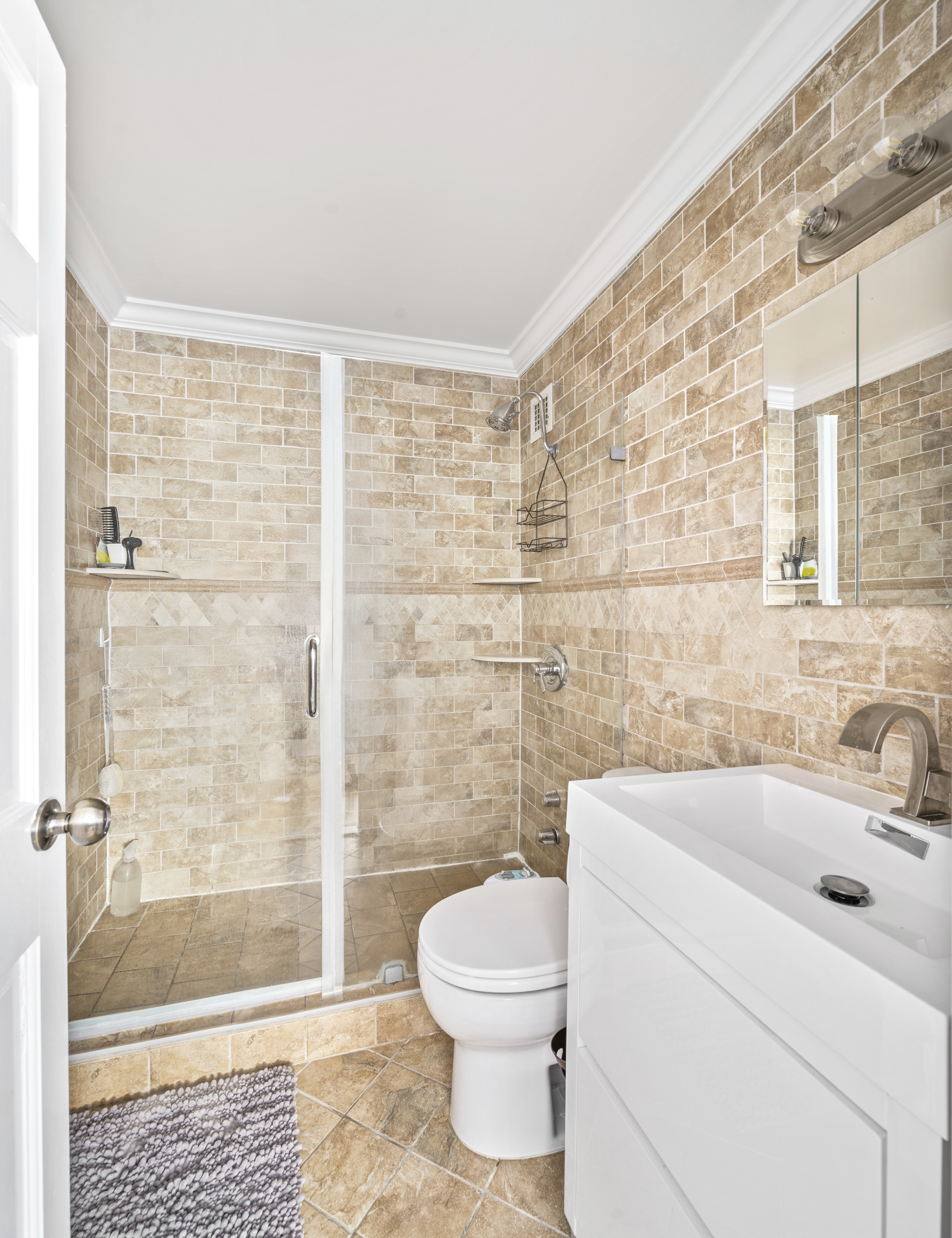 201 East 79th Street, Unit 6A Manhattan, NY 10075 - Photo 9 of 11 a bathroom with a sink toilet and shower