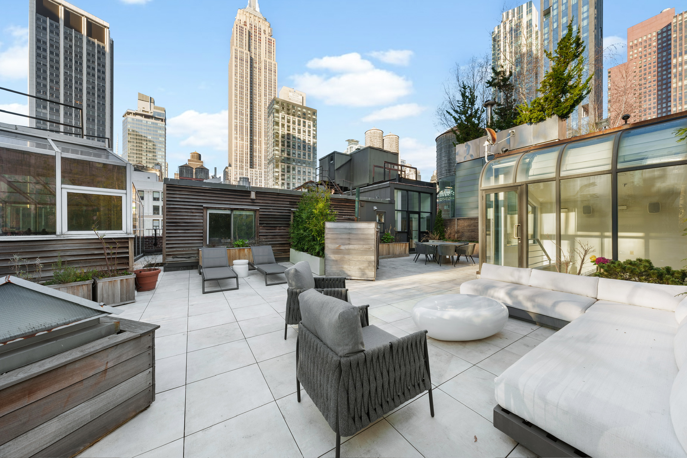 1200 Broadway, Unit PH89 Manhattan, NY 10001 - Photo 34 of 47 a view of the patio with couches and a fire pit and wooden floor