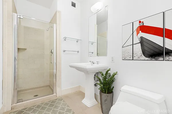 252 7th Avenue, Unit 10I Manhattan, NY 10001 - Photo 13 of 25 a bathroom with a sink a mirror and a shower