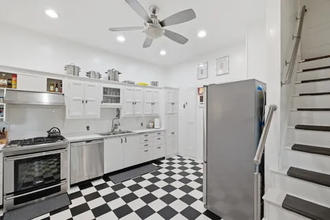 a kitchen with stainless steel appliances a refrigerator and a stove top oven