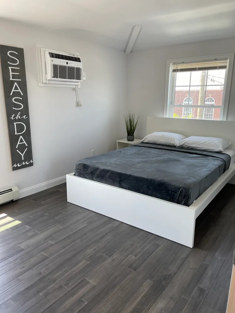 a room with a bed and wooden floor