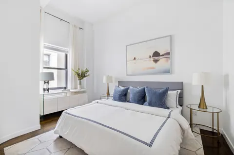 a bedroom with a large bed and a chandelier