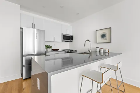 a kitchen with stainless steel appliances granite countertop a sink a stove a refrigerator a counter top space and cabinets