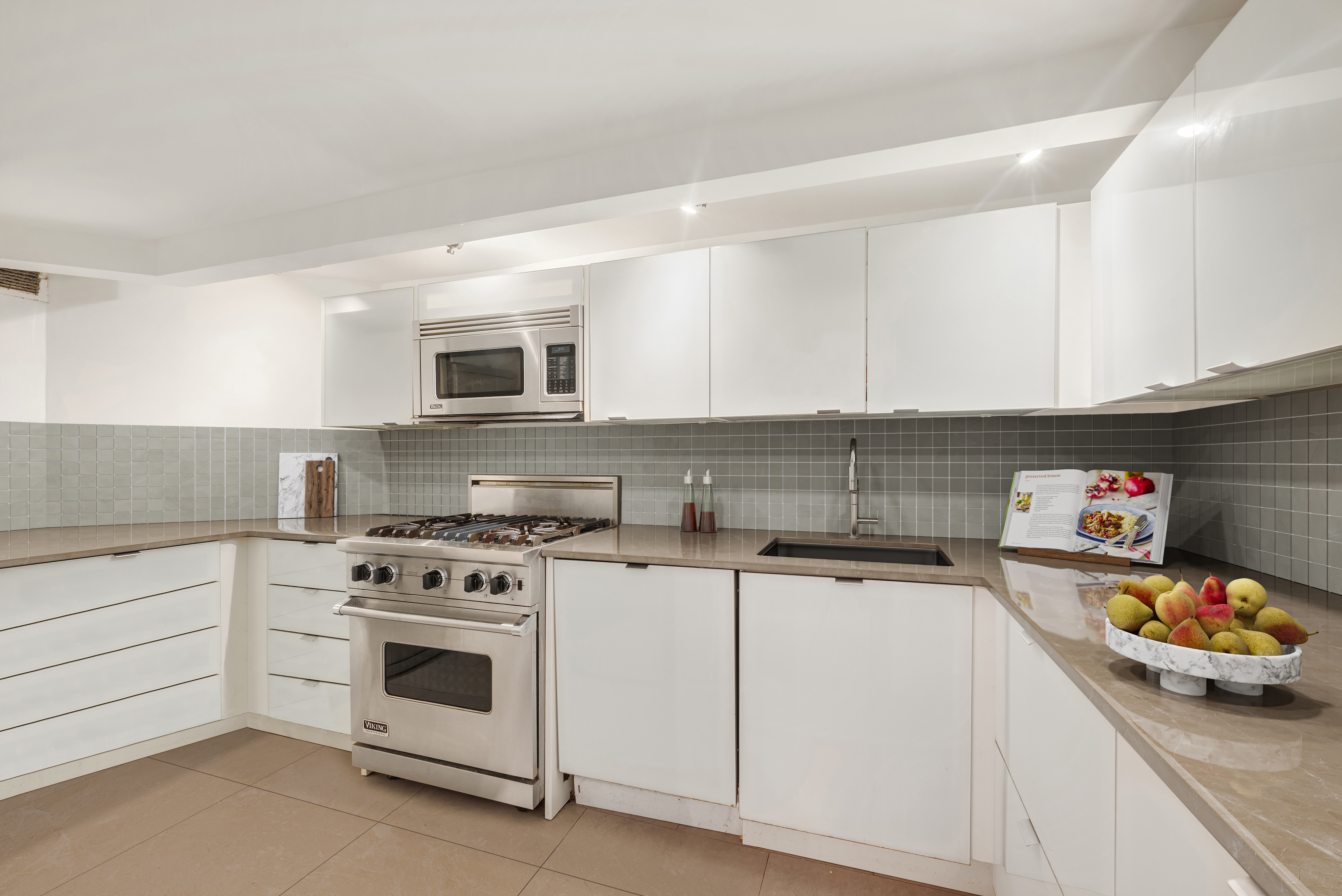 421 Hudson Street, Unit 409 Manhattan, NY 10014 - Photo 4 of 12 a kitchen with a sink a stove and cabinets