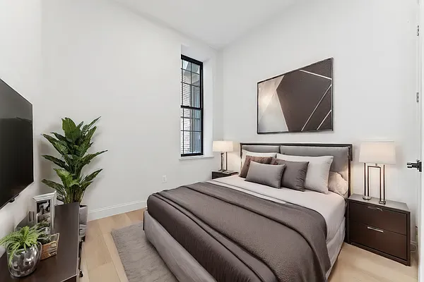 a bedroom with a large bed and a potted plant