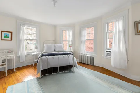 a bed sitting in a bedroom next to a window