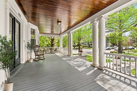 a porch with wooden floor outdoor seating and yard