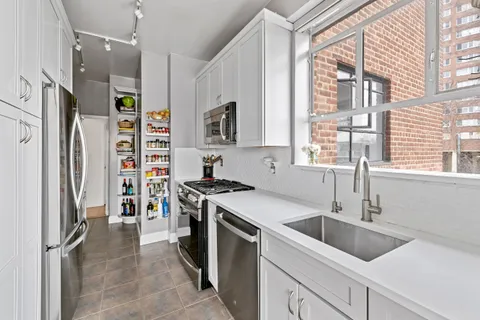 a kitchen that has a sink a stove and refrigerator