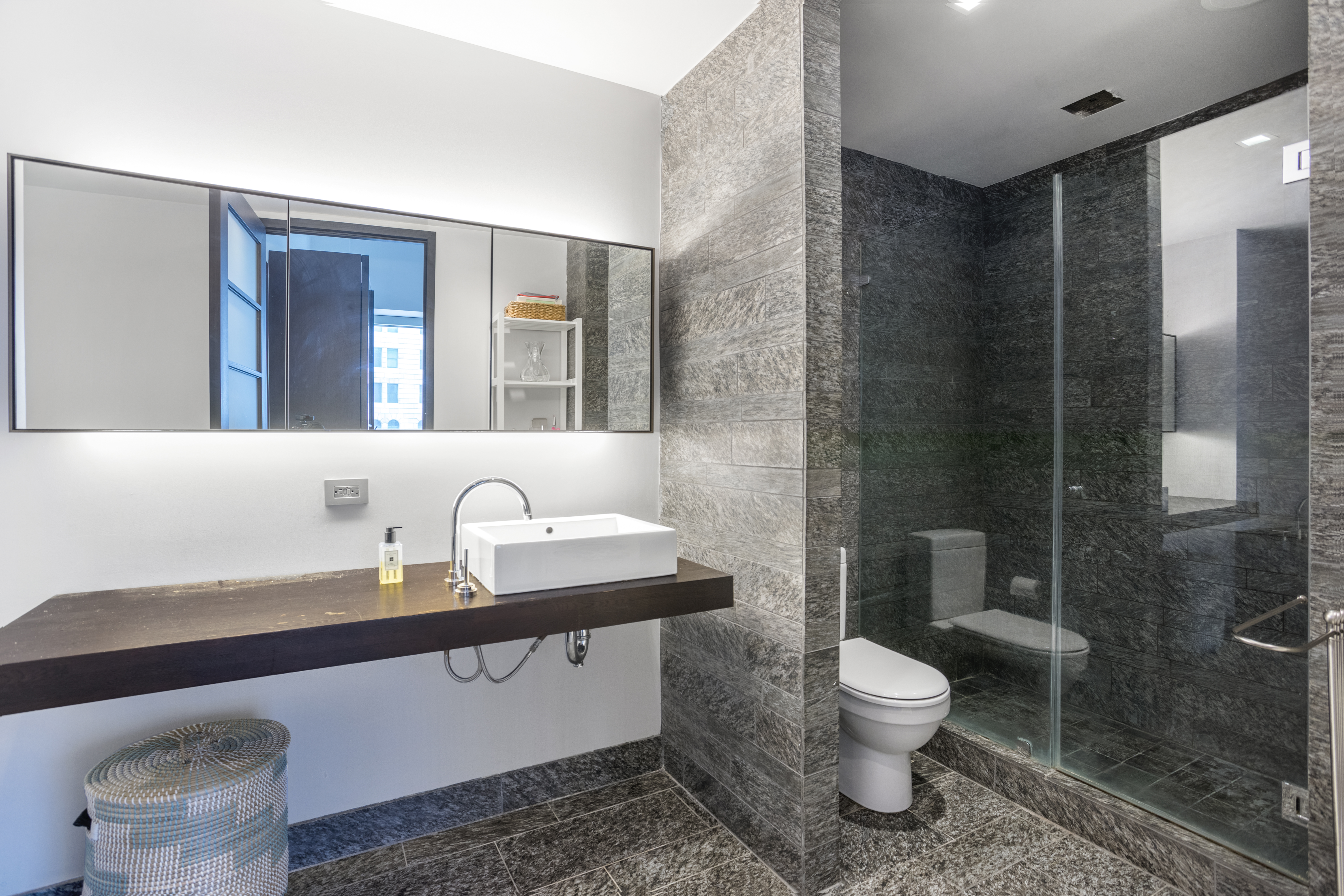 20 Pine Street, Unit 409 Manhattan, NY 10005 - Photo 6 of 11 a bathroom with a toilet sink and mirror