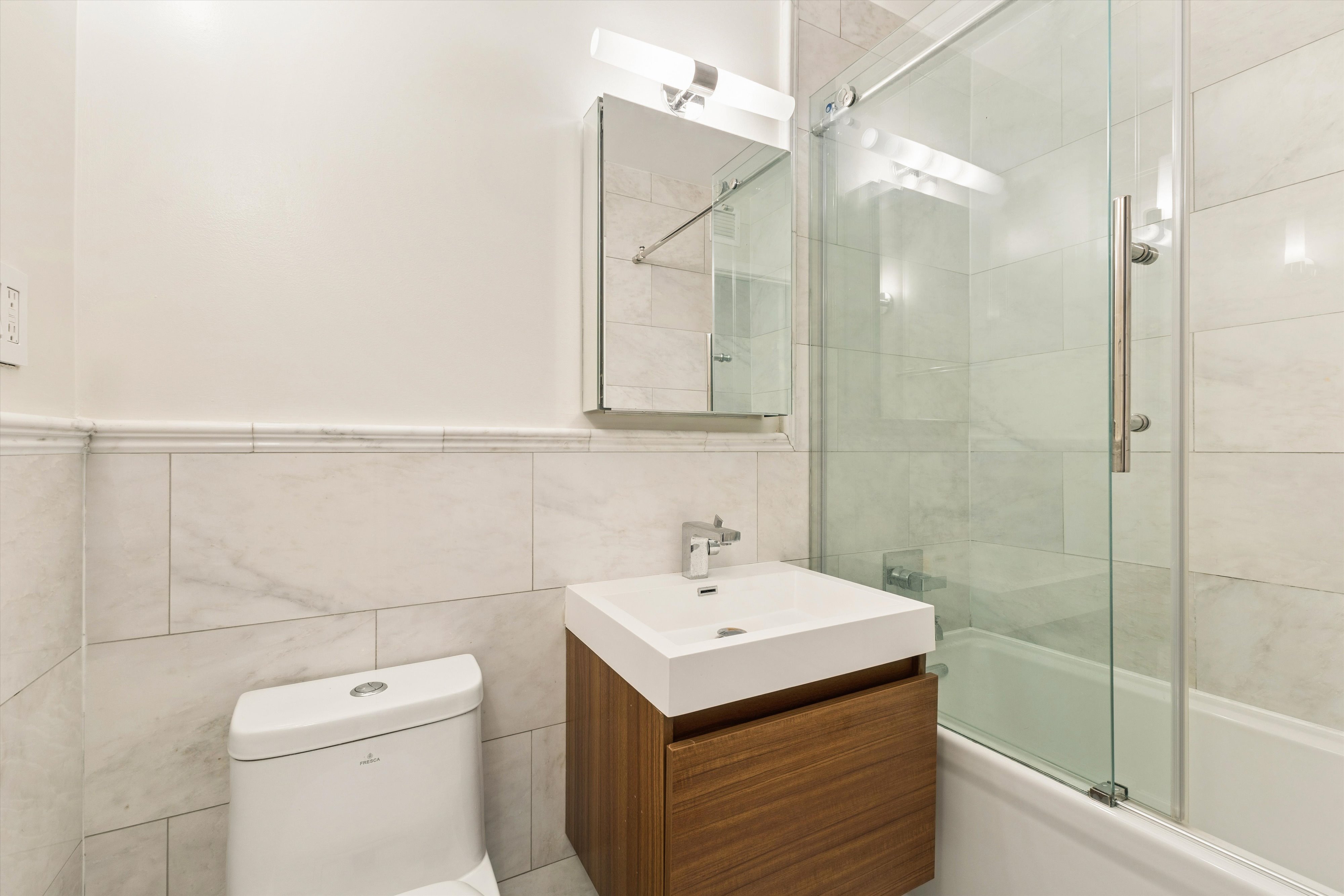 1919 Madison Avenue, Unit 418 Manhattan, NY 10035 - Photo 7 of 16 a bathroom with a sink a toilet and shower