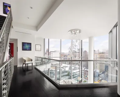 a view of a living room with furniture and floor to ceiling windows