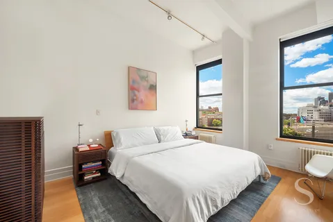 a bedroom with a bed and a large window