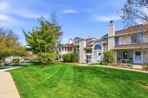 a front view of a house with a garden and plants