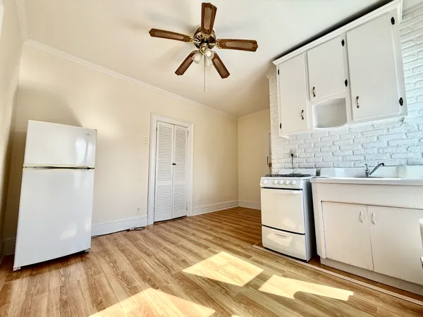 a kitchen with a refrigerator and white cabinets