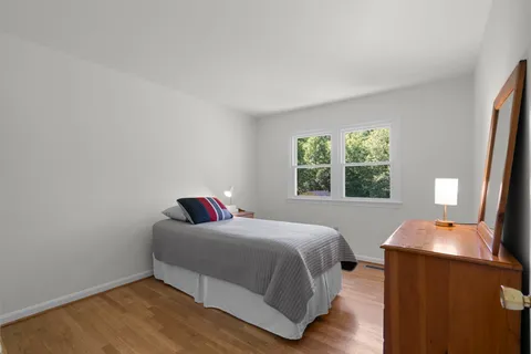 a bedroom with a bed and wooden floor