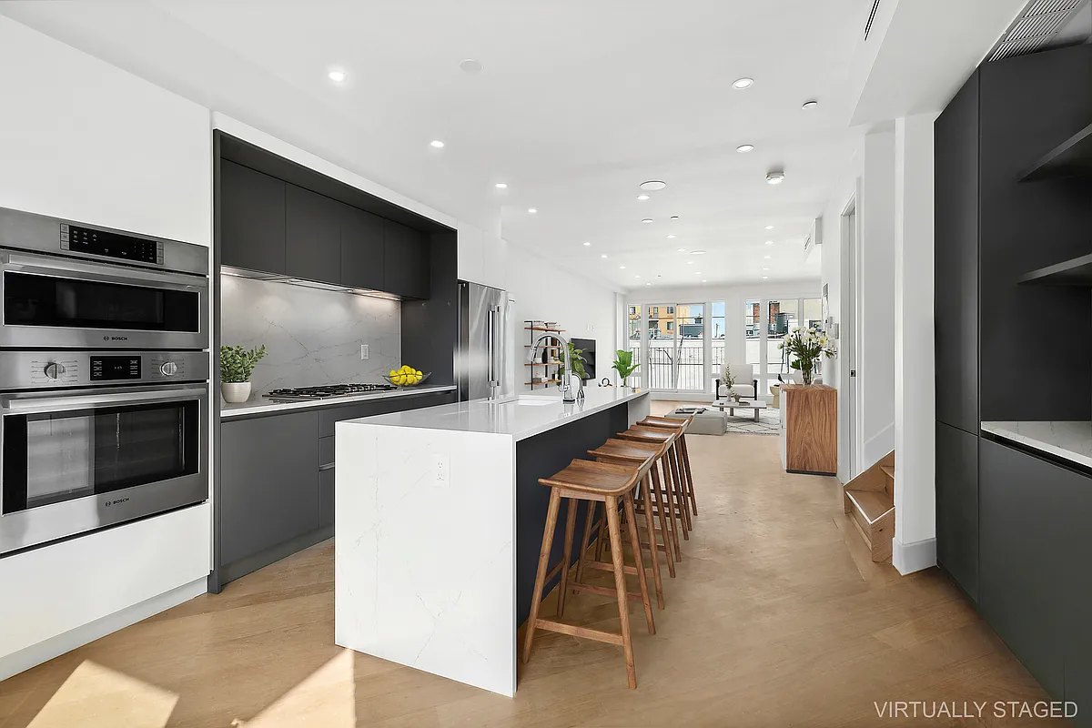 483 Hart Street, Unit PH Brooklyn, NY 11221 - Photo 4 of 17 a kitchen with stainless steel appliances kitchen island granite countertop a refrigerator and a stove top oven