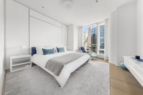 a bedroom with a bed and a large window