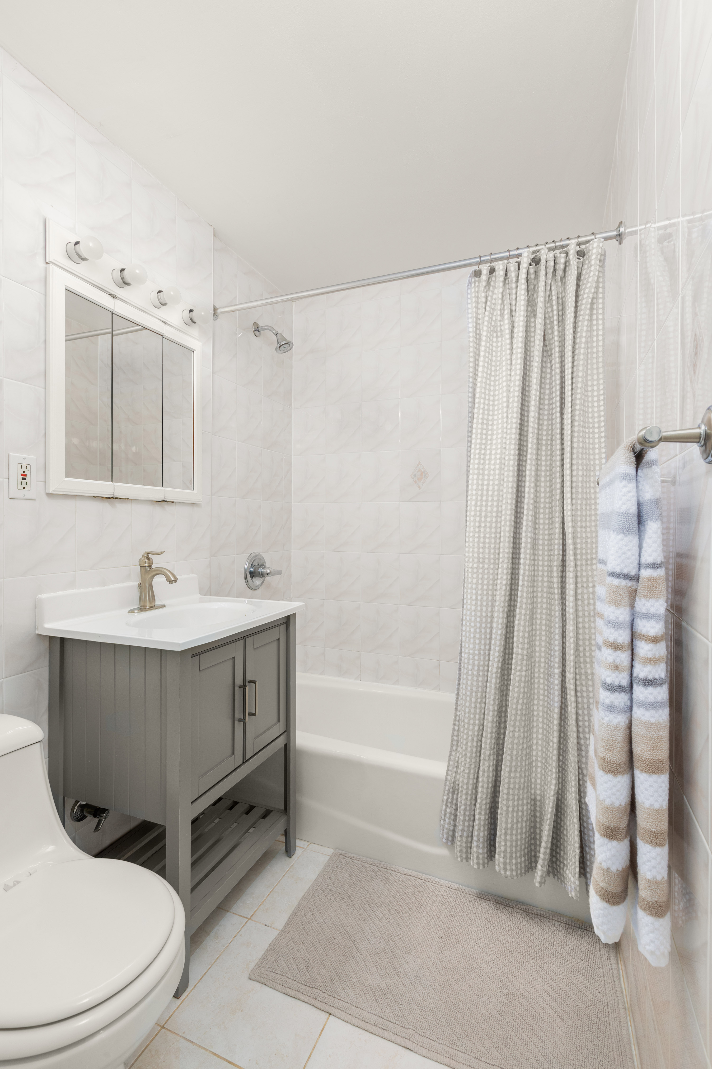 342 East 53rd Street, Unit 1G Manhattan, NY 10022 - Photo 6 of 9 a bathroom with a sink a toilet and shower curtain