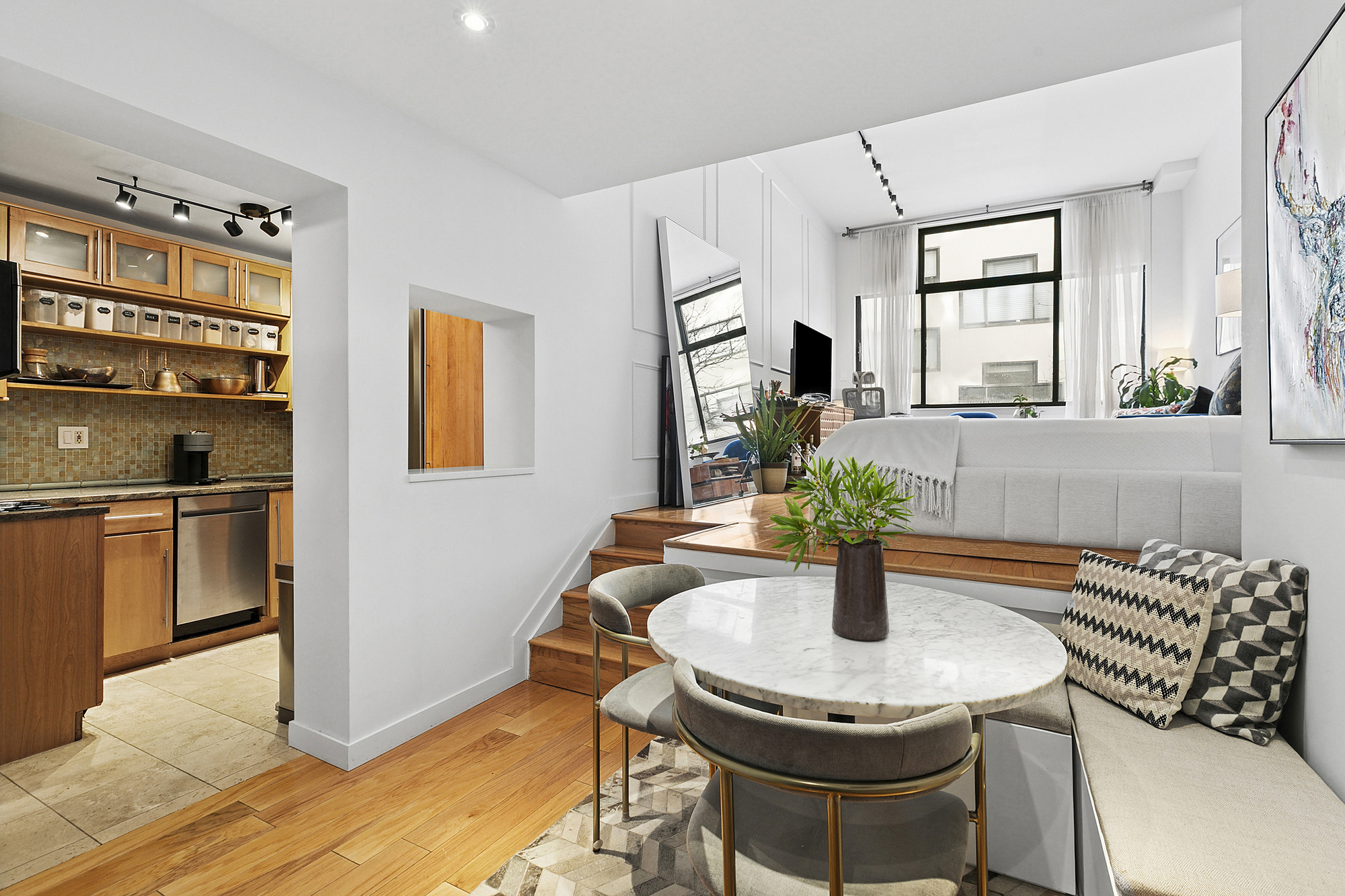 77 Bleecker Street, Unit 214 Manhattan, NY 10012 - Photo 3 of 5 a dining room with stainless steel appliances furniture a window and kitchen view