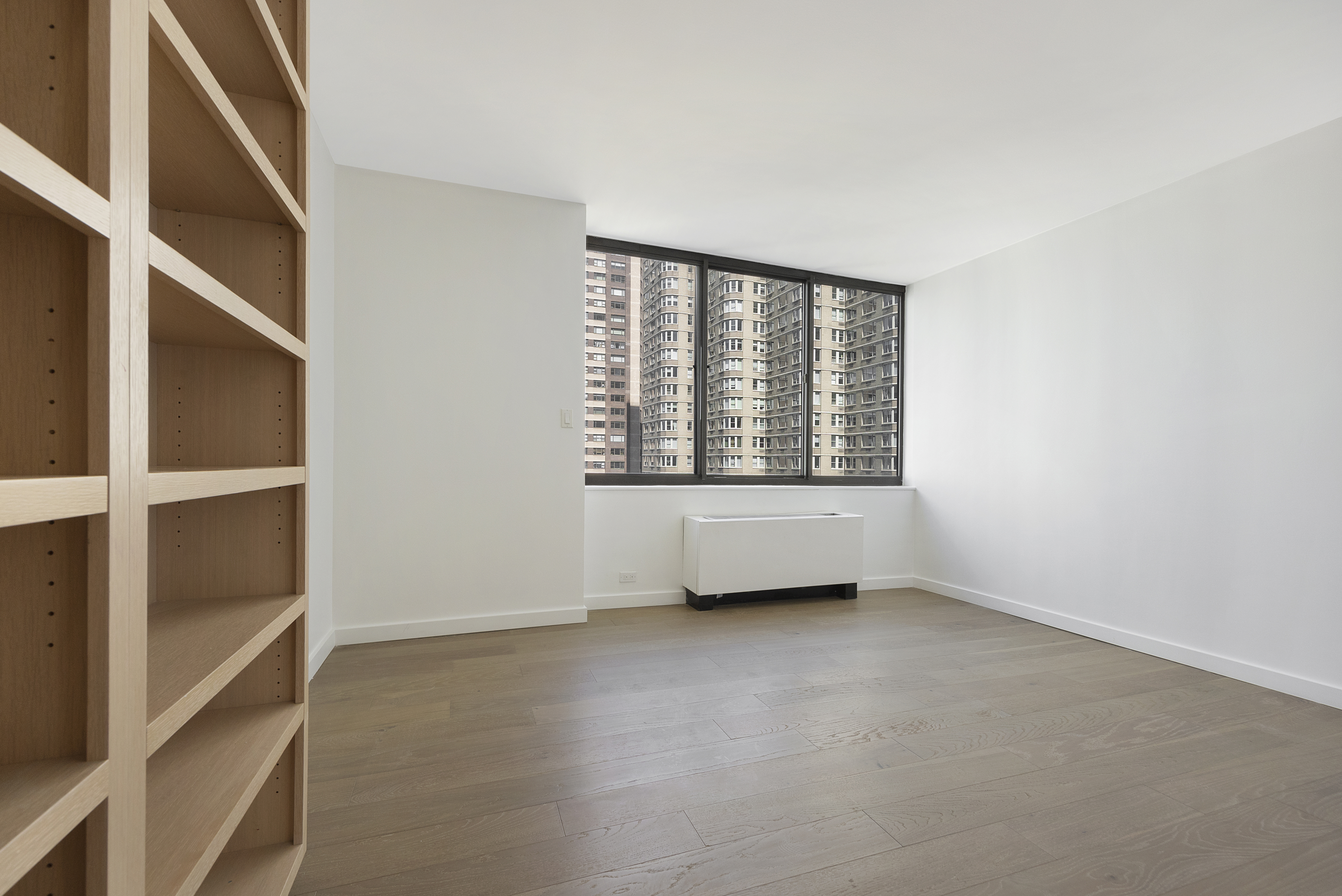 62 West 62nd Street, Unit 18A Manhattan, NY 10023 - Photo 9 of 16 an empty room with windows