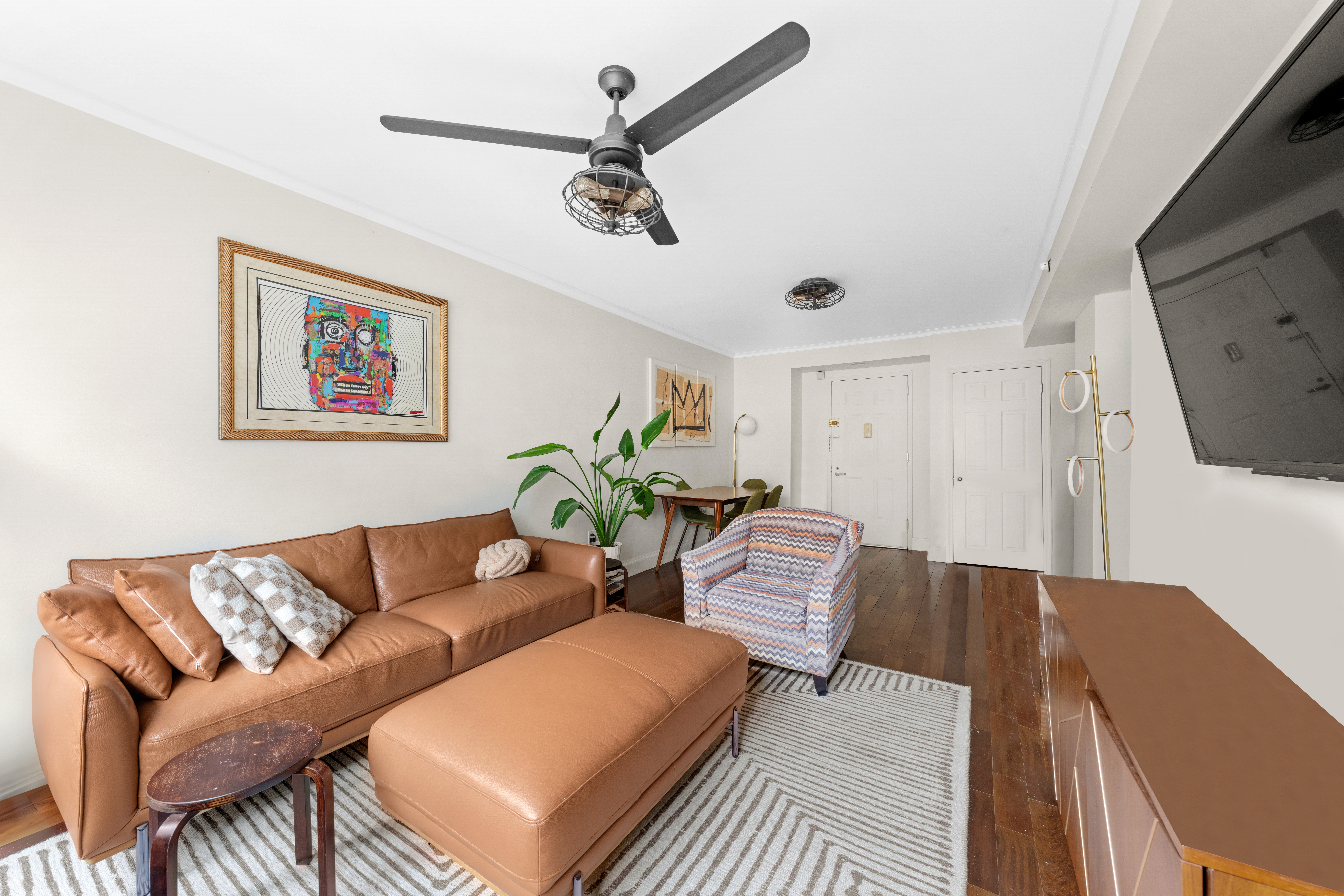163 St Nicholas Avenue, Unit 4H Manhattan, NY 10026 - Photo 2 of 16 a living room with furniture and a flat screen tv