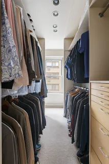 a view of walk in closet with clothes and shoes