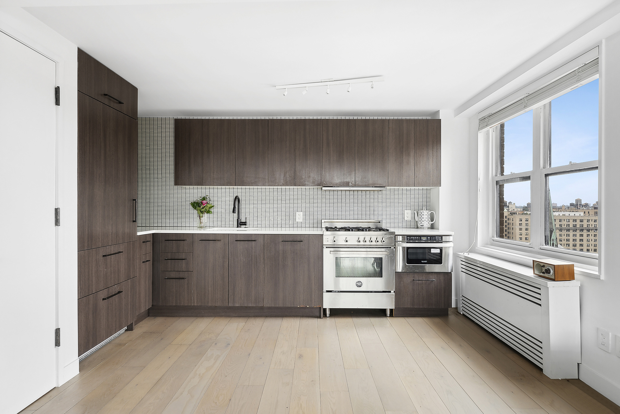 175 West 95th Street, Unit 18G Manhattan, NY 10025 - Photo 2 of 14 a kitchen with granite countertop a stove top oven sink and cabinets