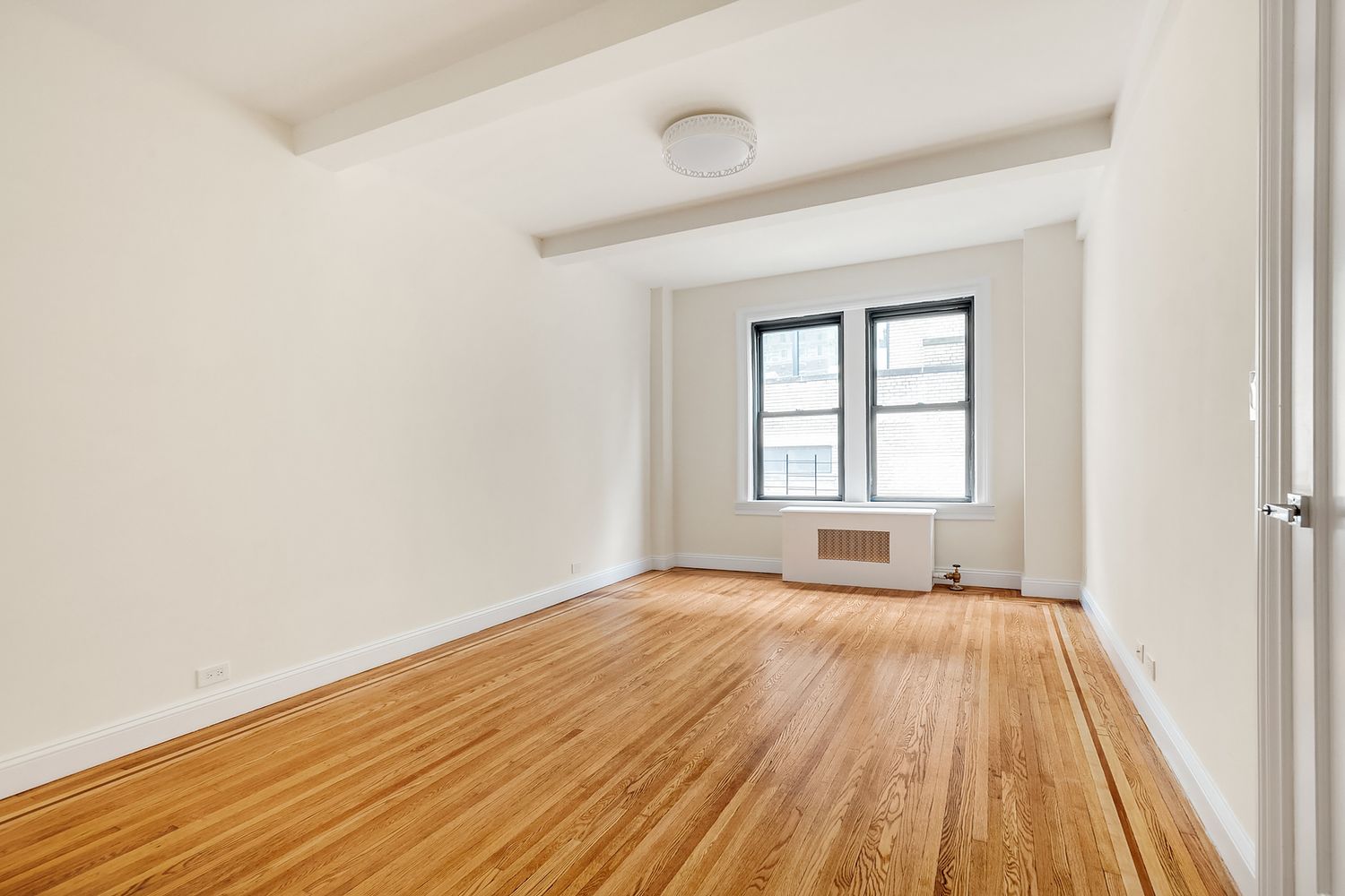 20 West 84th Street, Unit 3A Manhattan, NY 10024 - Photo 4 of 5 a view of an empty room with wooden floor and a window