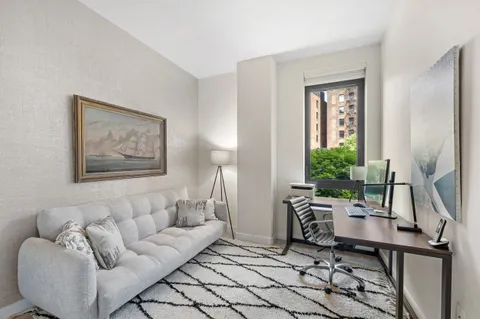 a living room with furniture a window and a flat screen tv
