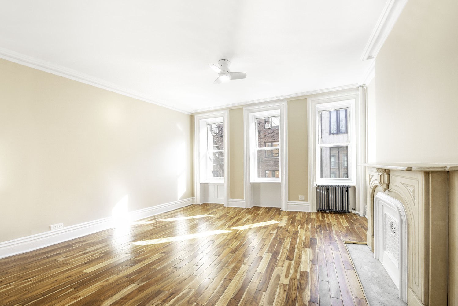 a view of a livingroom with wooden floor and a ceiling fan