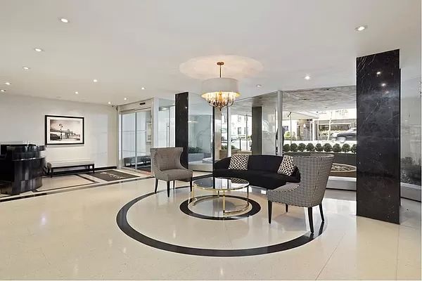 35 Sutton Place, Unit 7E Manhattan, NY 10022 - Photo 15 of 18 a dining room with furniture a chandelier and kitchen view