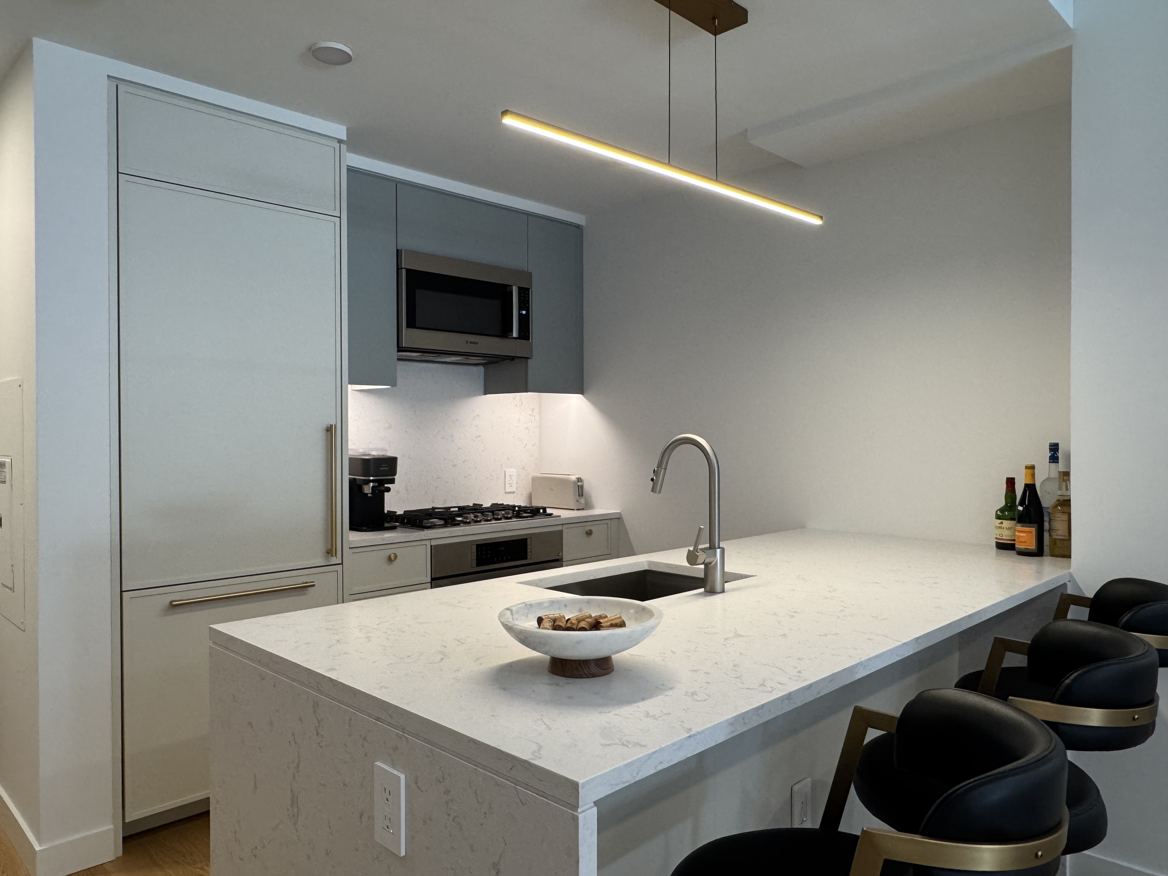 18 West 55th Street, Unit 7B Manhattan, NY 10019 - Photo 10 of 20 a kitchen with a sink a stove and cabinets